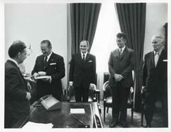 ["Black and white photograph print of Carl Albert, President Josip B. Tito of Yugoslavia, and others standing in Albert's office. November 1971"]