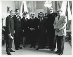 ["Black and white photograph print of Carl Albert standing with an unidentified group in Albert's office."]