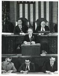 ["Black and white photograph print of Carl Albert and James O. Eastland with others during a joint session of Congress."]