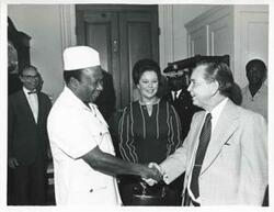 ["Black and white photograph print of Carl Albert shaking hands with William R. Tolbert, Jr. (President of Liberia). Shirley Temple Black is in the background. September 23, 1976"]
