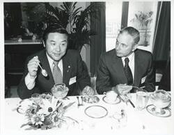 ["Black and white photograph print of Two men eating dinner during the Korean-U.S. Interparliamentary Conference. July 22-23, 1973"]