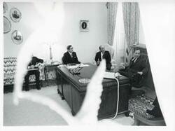 ["Black and white photograph print of Carl Albert seated at his desk and talking with unidentified men seated beside him during the Korean-U.S. Interparliamentary Conference. July 22-23, 1973"]
