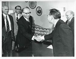 ["Black and white photograph print of Carl Albert in various poses with unidentified people."]