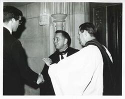 ["Black and white photograph print of Carl Albert speaking with an unidentified group of men."]