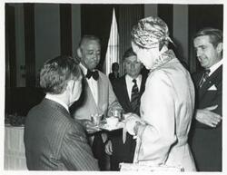 ["Black and white photograph print of Carl Albert talking with Queen Margrethe and others."]