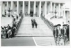 ["Black and white photograph print of Carl Albert, Nelson Rockefeller, John Rhodes, John McFall, Robert C. Byrd, the Sergeant-at-Arms, John Brademas, and others on the steps of the U. S. Capitol. On the side of the steps are men in Revolutionary War costumes. During Queen Elizabeth's visit to Congress, 1976"]