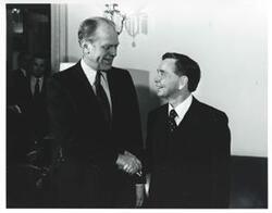 ["Black and white photograph print of Gerald R. Ford shaking hands with Carl Albert."]
