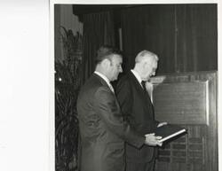 ["Black and white photograph print of John W. McCormack standing with an unidentified man.N1698"]