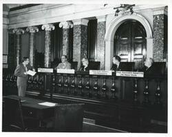 ["Black and white photograph print of Senator Estes Kefauver, Senator Karl Mundt, Representative Carl Albert, and Representative Kenneth Keating at an unknown function."]