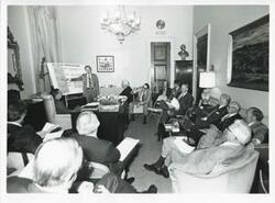 ["Black and white photograph print of Meeting with Committee Chairman and Roz Wyman."]