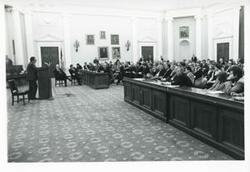 ["Black and white photograph print of Carl Albert speaking to a large group of people at an unidentified function."]
