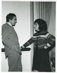 ["Black and white photograph print of Jan Lipsen speaking with an unidentified man."]