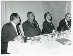 ["Black and white photograph print of E. T. Dunlap and Carl Albert seated at a dinner table."]