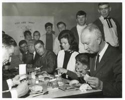 ["Black and white photograph print of Carl Albert seated at a dinner table with Timmy Faas and others. March of Dimes, 1968"]