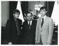 ["Black and white photograph print of Carl Albert standing with two unidentified men."]