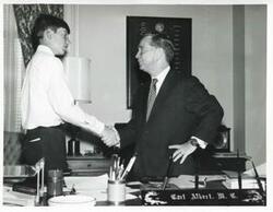 ["Black and white photograph print of Carl Albert shaking hands with an unidentified man."]
