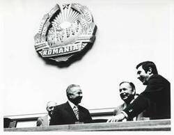 ["Black and white photograph print of Carl Albert speaking with some men in a building in Romania. House delegation trip to USSR, Romania, Yugoslavia. August 1975"]
