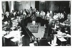 ["Black and white photograph print of Carl Albert and Mary Albert seated at a table with several others during the House delegation trip. August 1975"]