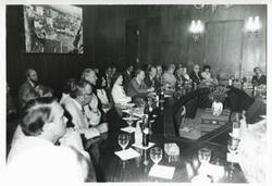 ["Black and white photograph print of Carl Albert and Mary Albert seated at a table with several others during the House delegation trip. August 1975"]