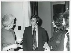 ["Black and white photograph print of Carole Howard and others at her farewell party."]