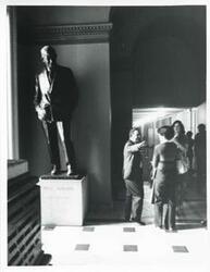["Black and white photograph print of Carl Albert speaking with Leslie Lytel near a statue of Will Rogers. April 1975"]