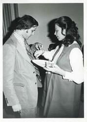 ["Black and white photograph print of Jane England Lawton talking with an unidentified man at her farewell party on March 8, 1974"]