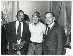 ["Black and white photograph print of Carl Albert and son David Albert posing with an unidentified black man."]
