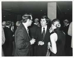 ["Black and white photograph print of several people at an unidentified function."]