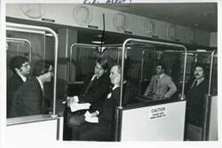["Black and white photograph print of Carl Albert, Joel Jankowsky, and others riding a tram."]