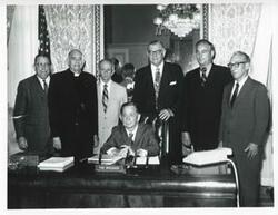 ["Black and white photograph print of Carl Albert posing with a group of unidentified men."]