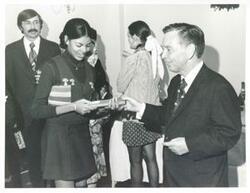 ["Black and white photograph print of Loise Butler, Polly Ritter, Carl Albert and others at office Christmas Party. Albert is giving Butler a gift. 1971"]