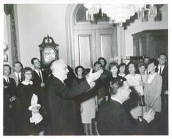 ["Black and white photograph print of John W. McCormack, Carl Albert, and several other people at an unidentified function."]