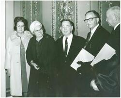 ["Black and white photograph print of Carl Albert standing with four unidentified people."]