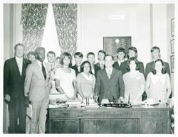 ["Black and white photograph print of Carl Albert posing with an unidentified group of people."]