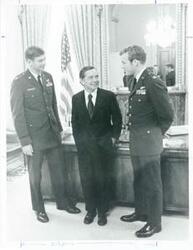 ["Black and white photograph print of Carl Albert talking with two Air Force officers in his office."]