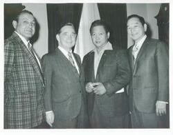 ["Black and white photograph print of Carl Albert standing with three unidentified men."]