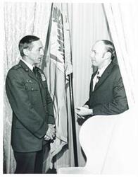 ["Black and white photograph print of Robinson Risner and James R. Jones talking at an unidentified function, November 1974"]