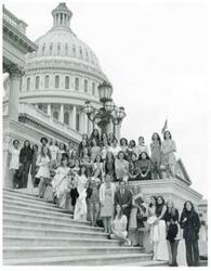 ["Black and white photograph print of girls from the National Cathedral School for Girls posing on the Capitol steps with Carl Albert."]