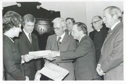 ["Black and white photograph print of Lindy Boggs, Mark Hatfield, Carl Albert, and John Rhodes at the Centennial Safe Opening Ceremony"]