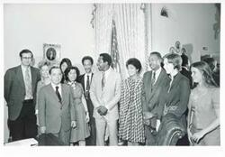 ["Black and white photograph print of Carl Albert posing with Hank Aaron and his wife and several other people."]