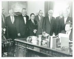 ["Black and white photograph print of Henry Cabot Lodge, Carl Albert, James O. Eastland, and John F. Kennedy Jr. with others at an unidentified function."]