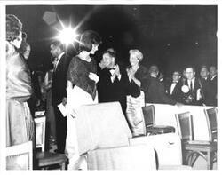 ["Black and white photograph print of Jacqueline Kennedy, Carl Albert, and several others at an unidentified function."]