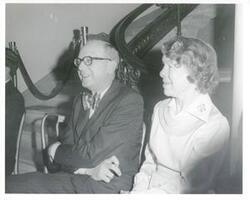 ["Black and white photograph print of Mary Albert seated next to an unidentified man during Carl Albert's birthday party."]