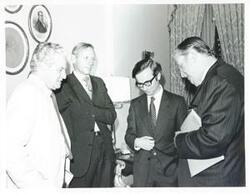 ["Black and white photograph print of Thomas E. Morgan standing with three unidentified men."]