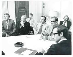 ["Black and white photograph print of Clement Zablocki and several men seated at a round table."]