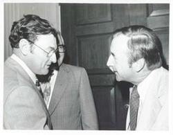 ["Black and white photograph print of Henry Reuss shaking hands with an unidentified man."]