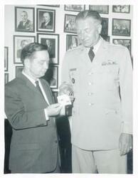 ["Black and white photograph print of Carl Albert standing with unidentified men."]