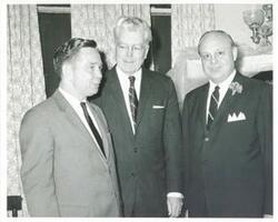 ["Black and white photograph print of Carl Albert posing with two unidentified men. May 24, 1964"]