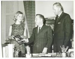 ["Black and white photograph print of Carl Albert standing with Howard Akers and an unidentified woman."]