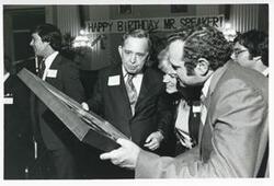 ["Black and white photograph print of Carl Albert holding up his new portrait of Oklahoma football on his birthday. 1976"]